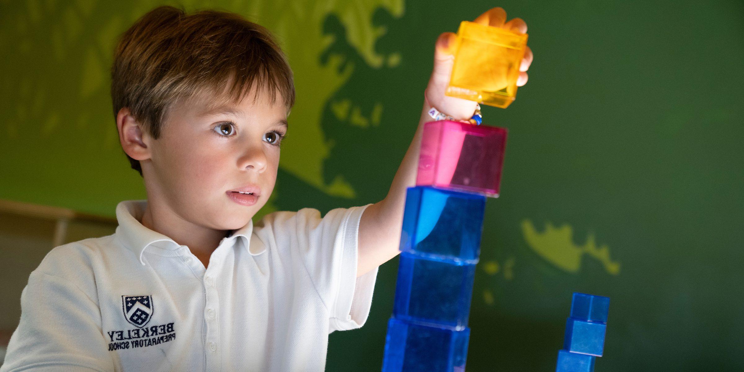 Boy playing with blocks on light table